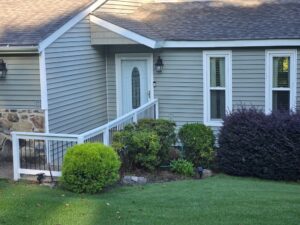 Residential construction with updated siding, entryway, and landscaping.