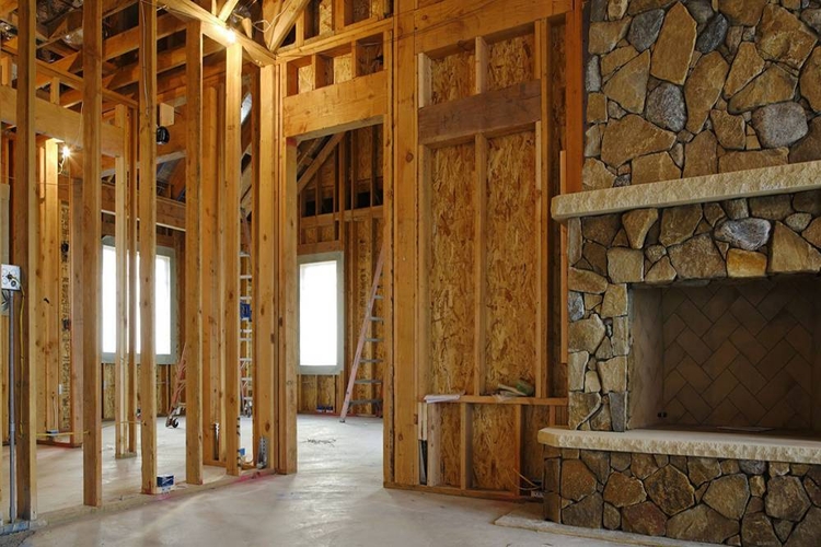 Residential construction site with wood framing and stone fireplace